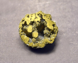 .Pyritized geode of quartz on a gray background