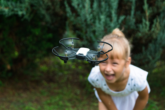 A little girl indulges and plays, takes herself to the copter and places the video on her blog. STEM education. Dron, bot, robotics technology.