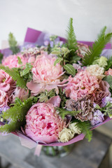 Work florist. Beautiful spring bouquet. Arrangement with mix flowers. The concept of a flower shop, a small family business. Pastel Color.