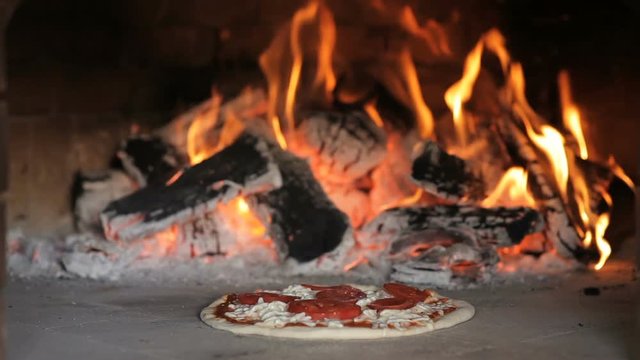 Italian pizza is cooked in a wood-fired oven