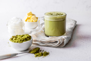 BULLETPROOF MATCHA. Ketogenic keto diet hot drink. Tea matcha blended with coconut oil and butter. Cup of bulletproof matcha and ingredients on white background