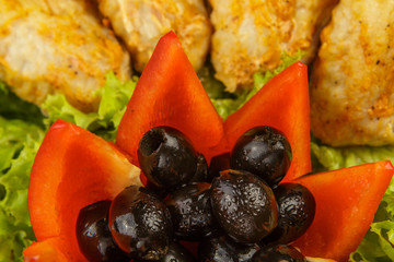 Dish from tartlets and chicken wings with the presence of lettuce leaves.