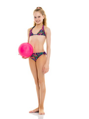 Little girl in a swimsuit with a ball