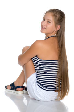 A teenage girl is sitting on the floor.