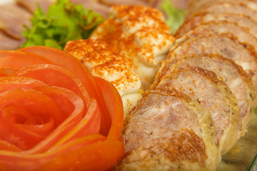 Meat sliced on a mirror dish decorated with verdure.