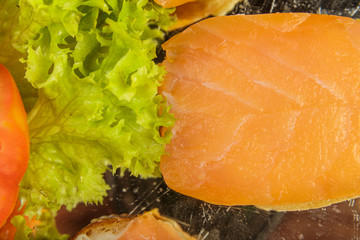 Dish of sandwiches with red fish tomato and greens.