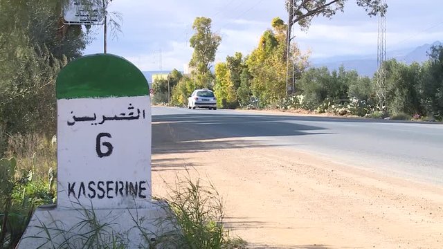 Tunisian road with a milestone indicating the distance to go to the city of Kasserine
