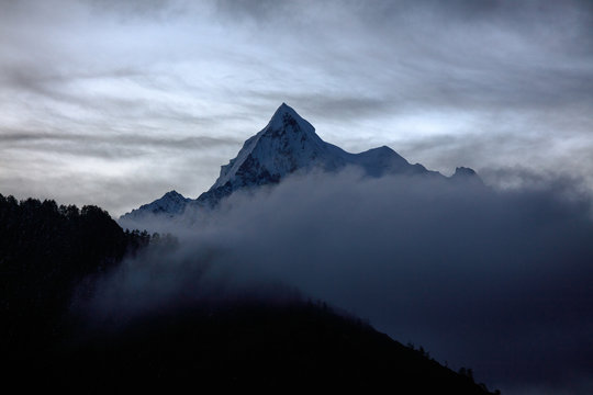 Chenadorje, holy snow mountain in Daocheng Yading Nature Reserve - Garze, Kham Tibetan Pilgrimage region of Sichuan Province China. Mountain shrouded in clouds and mist early in the morning © Cedar