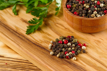 Colored pepper peas on a table with green parsley