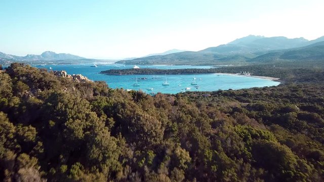 View from above, aerial view of a transparent and turquoise sea with some boats and yachts. Emerald Coast, Sardinia, Italy.