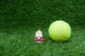 Merry Christmas with Santa with tennis ball on green grass 