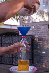 Hand is pouring the used oil