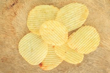 crispy potato chips junk food unhealthy food on wooden