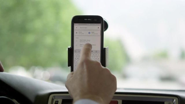 Person using maps on phone in car to get directions to destination.