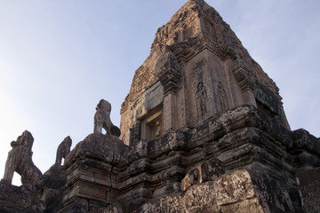 Fototapeta premium Angkor Cambodia, twilight view of tower at Pre Rup a 10th century hindu temple with stone animal statues on staircase