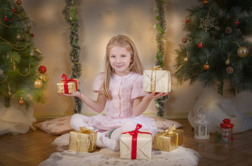 Obraz na płótnie Canvas Cute girl choosing best gifts at Christmas