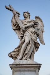 Fototapeta na wymiar Angel with the cross sculpture by Ercole Ferrata on the Pont Sant'Angelo bridge in Rome