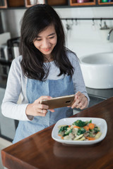 woman taking picture of food
