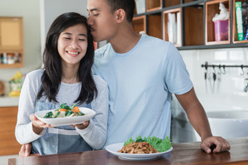 young asian couple at the kitchen cooking