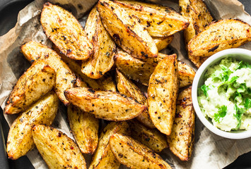 Crispy baked potato with avocado greens sauce. Delicious snack, top view