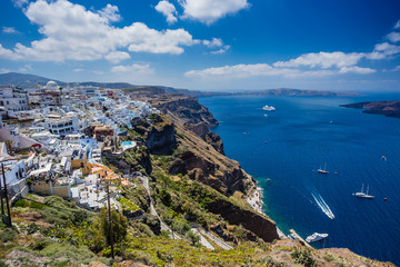 Fototapeta na wymiar Gourgeous view from white walled town of Fira in Santorini, Greece, with ocean, cliffs and caldera of Santorini in the background.