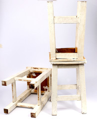 Wooden chair with white backdrop.