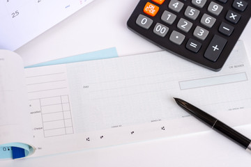 Checkbook, calendar and calculator on the white background. Payday concept.