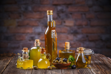 Various olive oil glass bottles with olive berries