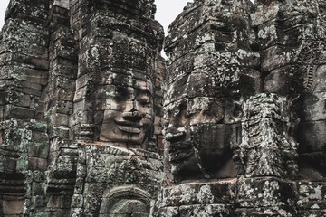 Faces of Bayon temple in Angkor Thom, The Bayon's most distinctive feature is the multitude of serene and smiling stone faces on the many towers