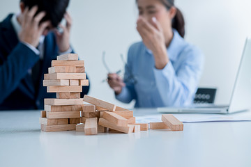 Problem Solving Business can't stop effect of dominoes continuous toppled with business team feeling sad and stress in office background. Failure Business Concept. - obrazy, fototapety, plakaty