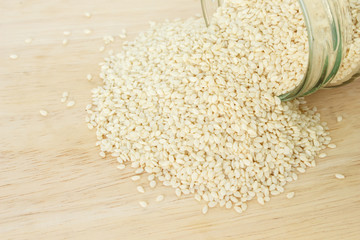 white sesame seed in jar on wood background