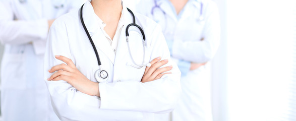 Unknown female doctor with medical staff  at hospital. Teamwork in medicine