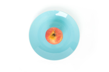 red apple on plate blue top focus on white background