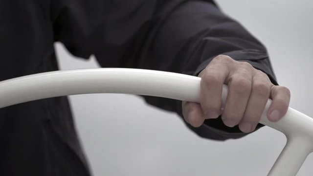 Hands of skipper turns the yacht wheel. Sailing transportation for water sports. Regatta as a lifestyle.