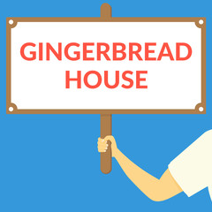 GINGERBREAD HOUSE. Hand holding wooden sign