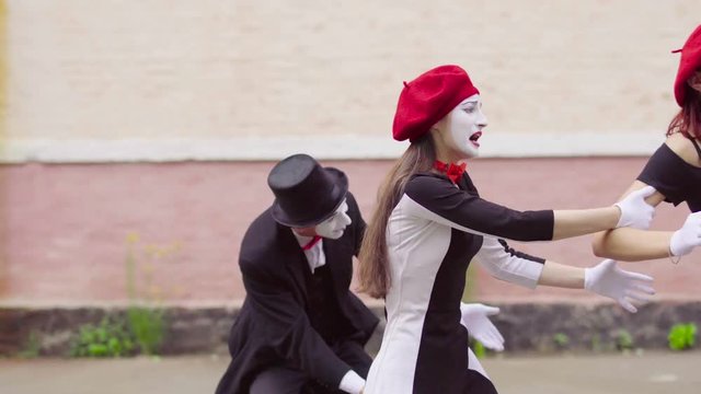 Funny mimes make perfomance near building