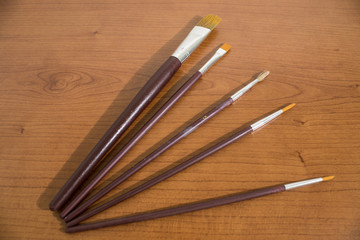 Lots of paintbrushes on a wood table