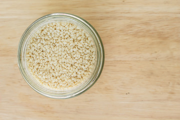 white sesame seed in jar on wood background