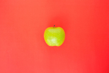 green apple on red background