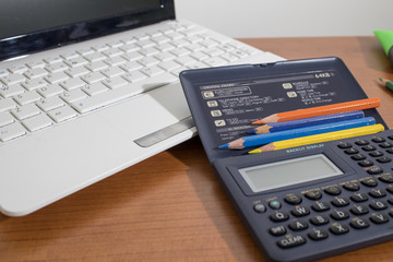 Stationery products, calculator, pencils and a laptop