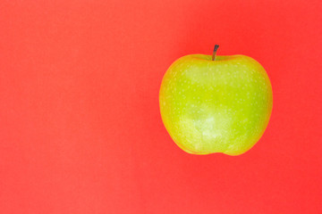 green apple on red background