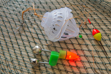 bait, wobbler and fishing accessories on a fishing net background