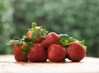 Fresh Strawberries on a wooden table top in the rain