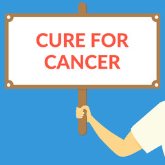 CURE FOR CANCER. Hand holding wooden sign