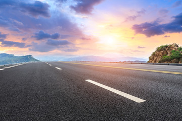 Asphalt highway and mountain natural landscape at sunrise