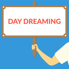 DAY DREAMING. Hand holding wooden sign