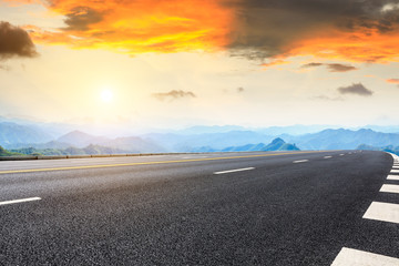 Asphalt highway and mountain natural landscape at sunrise