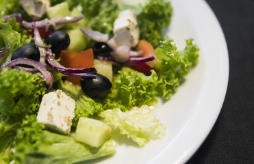 Caesar salad with chicken fillet and parmesan cheese, onion, olives, salad.