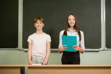 student girls are sitting at a Desk