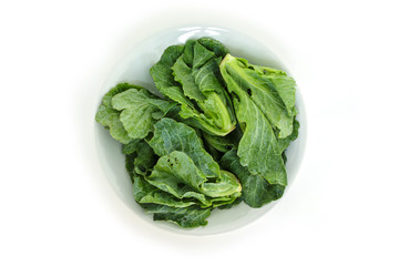 chinese kale on plate top view on white background